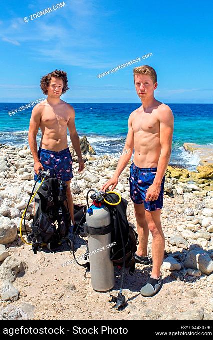 Two dutch male divers on beach of Bonaire with diving gear