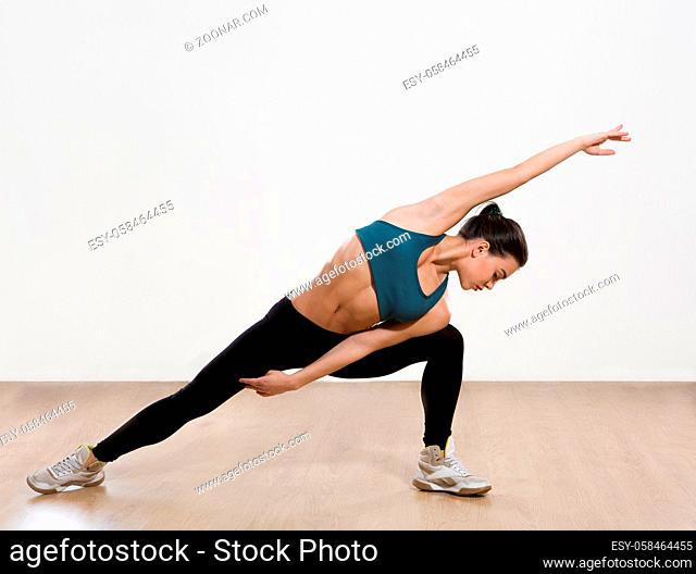 Picture of professional fitness yoga with muscles training over white background. Beautiful woman practicing yoga asana in studio