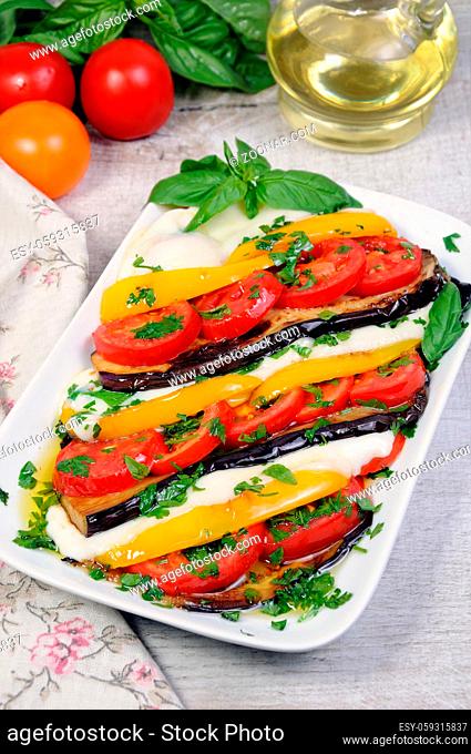 Baked eggplants with tomatoes, yellow pepper and slices mozzarella