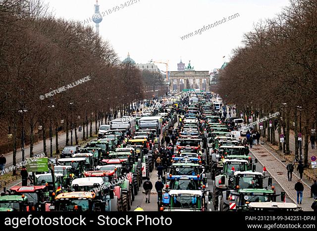 18 December 2023, Berlin: Farmers with tractors bearing the slogan ""If the farmer dies, the land dies"" take part in a demonstration organized by the German...