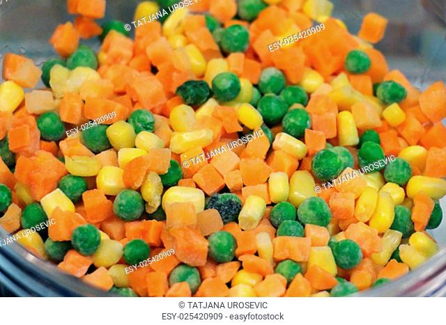 Frozen corn peas and carrots in bowl