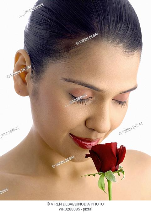 South Asian Indian woman holding and smelling red rose MR 702