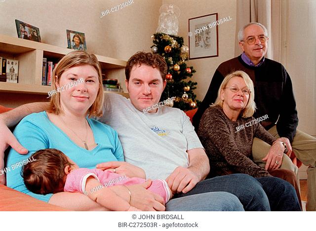 Family group with three generations sitting together in living room