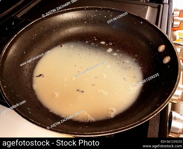 oily grease or fat in frying pan or skillet on stove