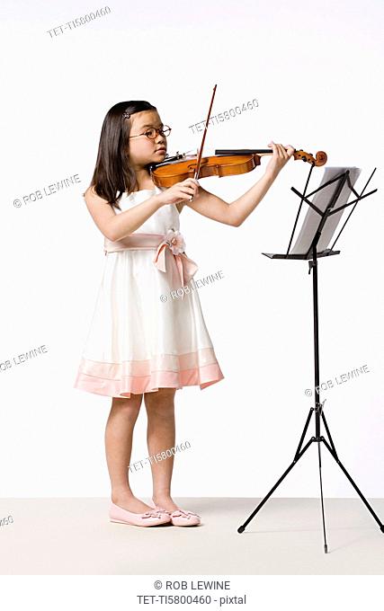 Girl 8-9 playing violin, studio shot
