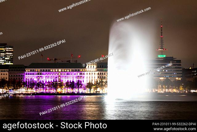 11 October 2023, Hamburg: The hotel ""Vier Jahreszeiten"" at the Binnenalster is illuminated in pink during a campaign of the organization ""Plan...