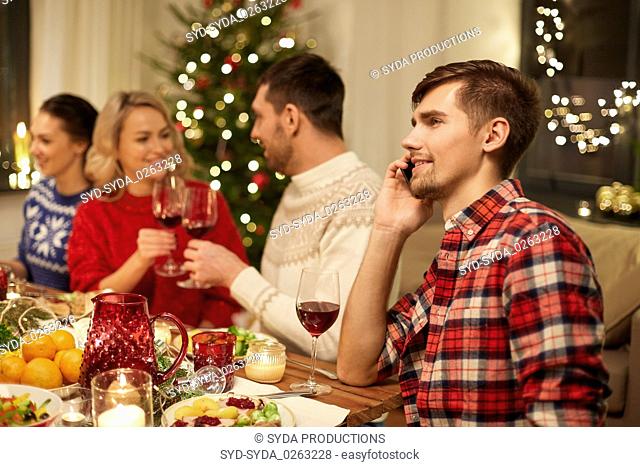 man calling on smartphone at christmas dinner