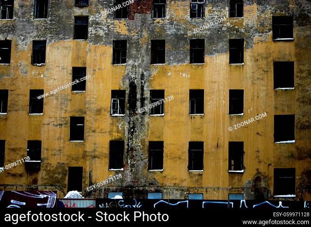 Wall with many glassless windows of abandoned building in St. Petersburg Russia
