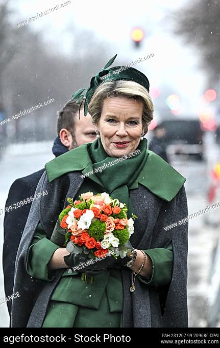 05 Diciembre 2023, Berlín: La reina Mathilde de Bélgica camina a la puerta de Brandenburgo con un ramo de flores. La pareja real belga ha venido a Alemania para...
