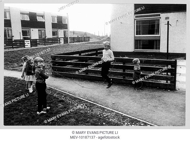 A group of little girls skipping with a rope on a modern housing estate at Peterlee, County Durham, England