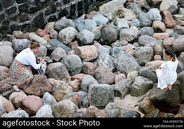 RUSSIA, KALININGRAD REGION - JULY 16, 2023: A woman poses by the rocks on the Baltic Sea coast in Zelenogradsk, 28km north of Kaliningrad