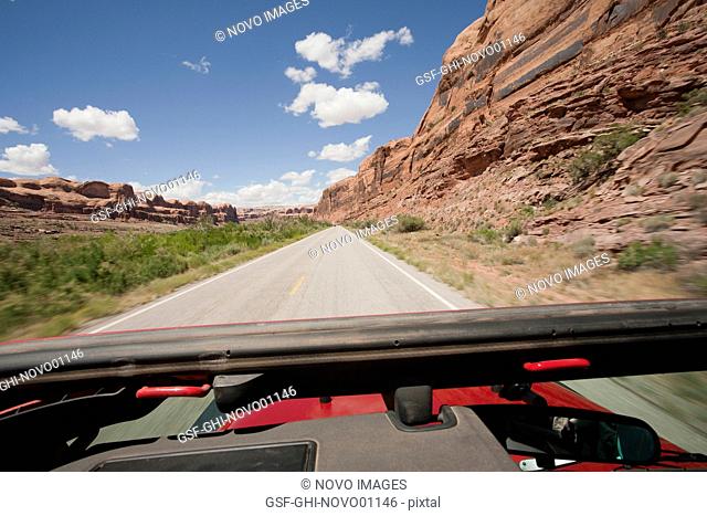 View of Remote Highway Across Red Rocks Through Jeep Sunroof, Moab, Utah, USA