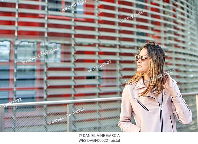 Portrait of woman wearing pink leather jacket and sunglasses, Barcelona, Spain