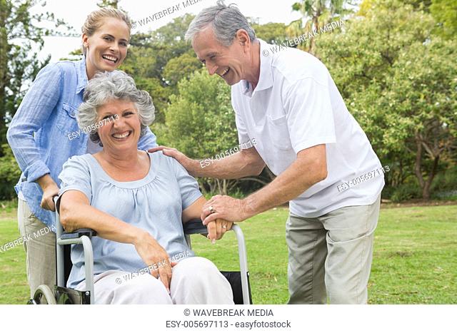 Happy woman in wheelchair with daughter and husband