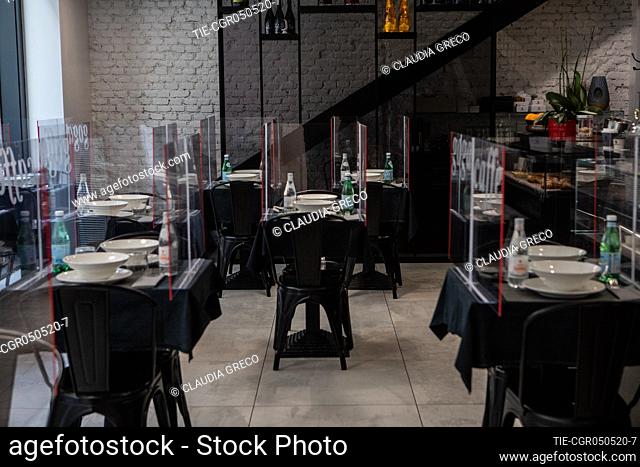 A restaurant prepares to welcome customers with plexiglass plates to divide the tables for the reopenig after the total lockdown , Milan, ITALY-05-05-2020