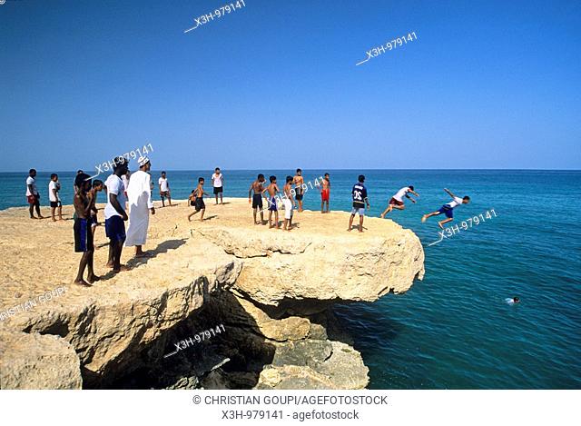 children diving into the sea from a rock, around Dibab, ,Sultanate of Oman, Arabian Peninsula, Asia