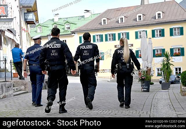 20 October 2020, Bavaria, Berchtesgaden: Policemen walk through the pedestrian zone of the city centre. From 14.00 hrs the exit restrictions in the...