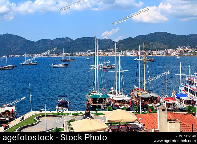 MUGLA, TURKEY - JUNE 1, 2015 : Top view of Marmaris Marina among mountains with sailing boats and yatches anchored, on blue sky background