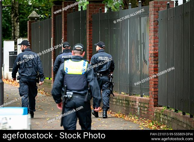 13 October 2023, Hamburg: Police officers walk on the sidewalk in front of the fence of the Jewish Talmud Torah School. Following the unprecedented attack by...