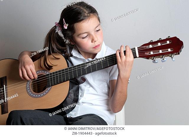 Child plays the guitar