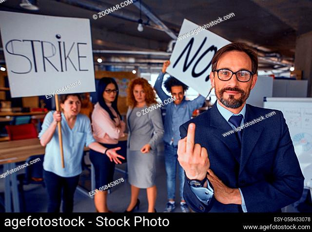 Director showing long finger, employees holding posters with words strike and no. Strike in the office. Toned concept