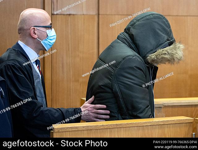 19 January 2022, Hessen, Frankfurt/Main: The accused doctor (r), who comes from Syria, is led by his lawyer Oussama Al-Agi into the security room of the Higher...