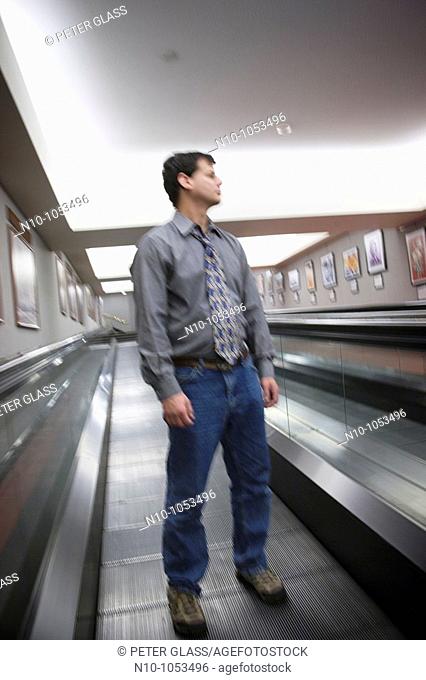 Young man standing on a moving walkway