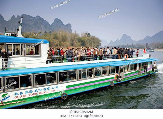 Tourist boat from Guilin Tourism Co. Ltd carries Chinese tourists along Li River between Guilin and Yangshuo, China