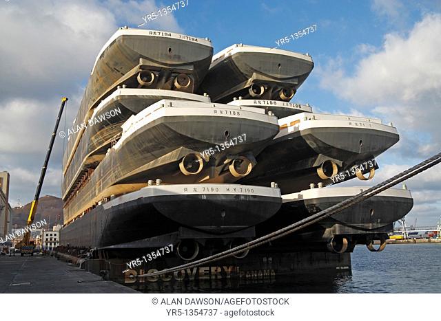Eight new boats stacked on platform being towed from shipyard in China to Europe  Puerto de La Luz, Las Palmas, Gran Canaria, Canary Islands, Spain