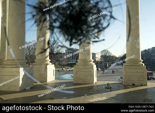 A view through the broken windows of the front entrance doors of the U.S. Capitol in the aftermath the morning after a riot by pro-Trump supporters who stormed...