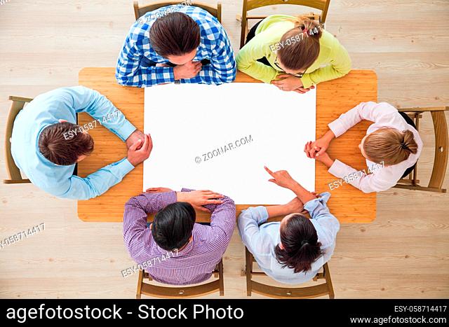 Hipster business teamwork brainstorming planning meeting concept, people team sitting around the table with white paper and pointing, copy space for content
