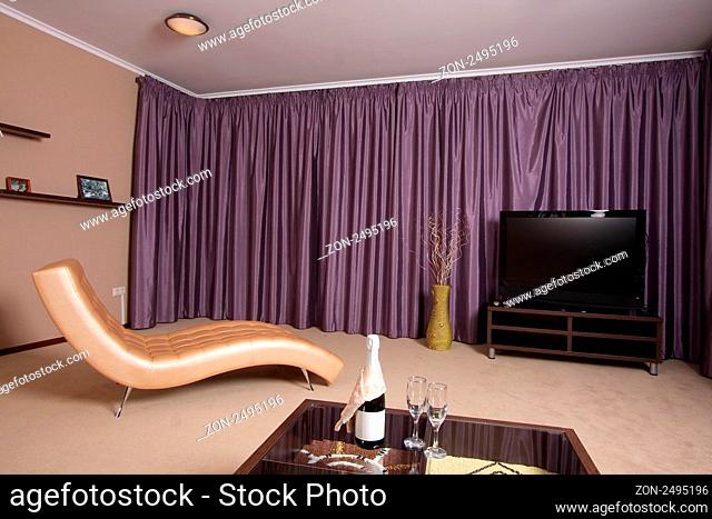 Beautiful modern interior with a convenient armchair from a genuine leather, the big television screen and a beautiful floor vase