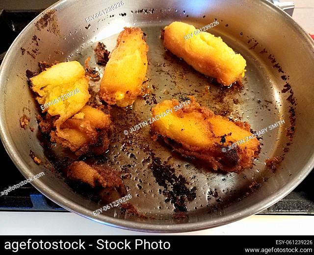 fried Puerto Rican corn fritters burned in frying pan
