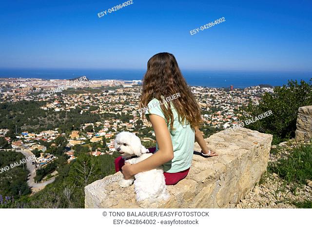 Girl wirh pet dog looking at Denia aerial view in alicante of Spain
