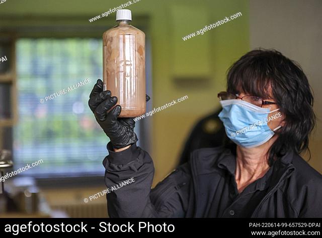 14 June 2022, Saxony-Anhalt, Raßnitz: A female judicial officer of the so-called special security and inspection service (BSRD) presents a bottle of homemade...