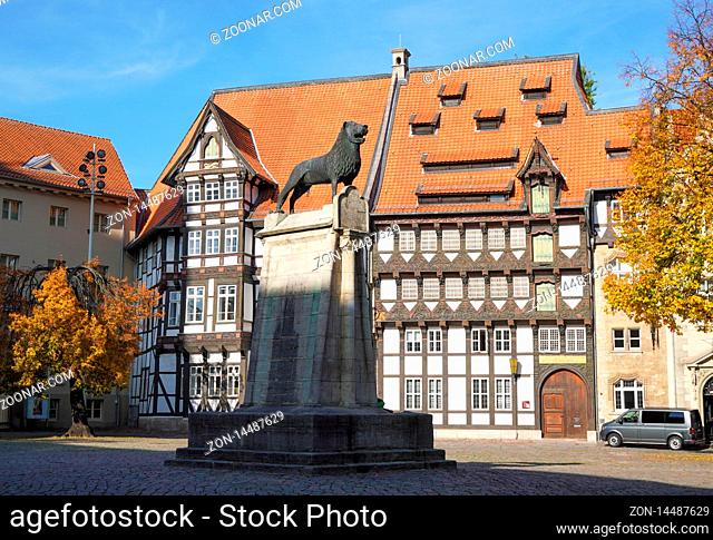 Braunschweig, Germany - October 15, 2019: Brunswick Lion monument located on historic Burgplatz castle square with timber-framed houses in the background