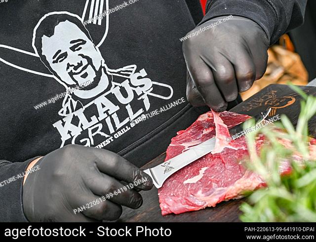 01 June 2022, Brandenburg, Hohenwutzen: Klaus Glaetzner, better known as cult griller Klaus, preparing a piece of meat. (to dpa-KORR