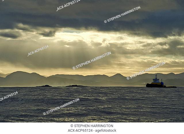A working tug heads north through the Inside Passage, British Columbia, Canada