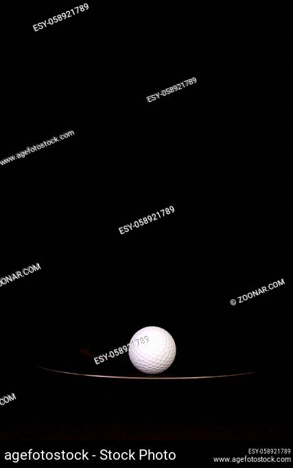 Black plate and golf ball on the black background