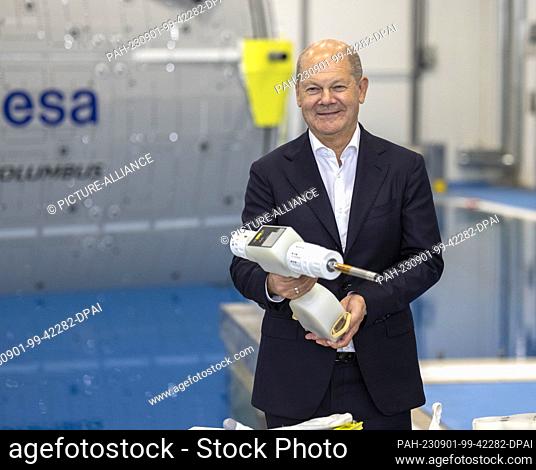 01 September 2023, North Rhine-Westphalia, Cologne: German Chancellor Olaf Scholz (SPD) holds a cordless screwdriver, which is part of the astronaut equipment