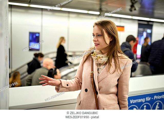 Austria, Vienna, young woman looking at map at underground station