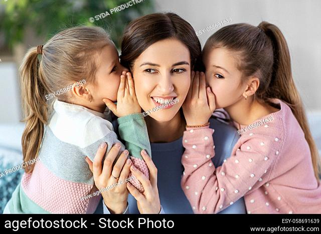 happy mother and daughters gossiping at home