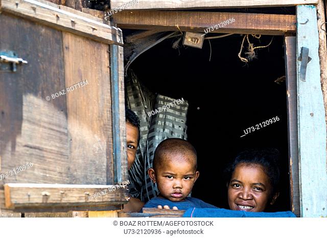 A Malagasy family peeking out their house window in a village near Antananarivo