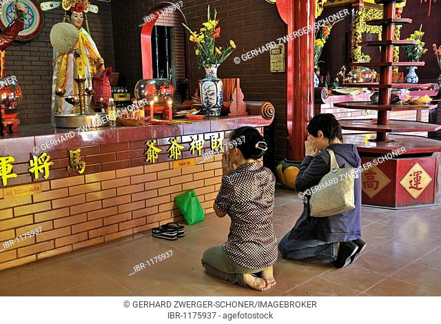 Two women kneeling and praying in front of a Buddha altar, Quan Am Pagoda, Ho Chi Minh City, Saigon, Vietnam, Southeast Asia