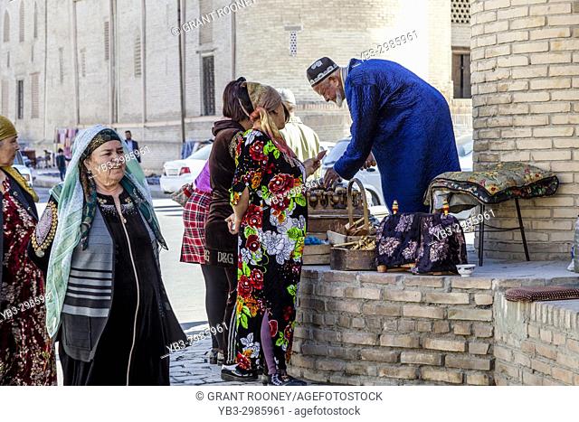 An Elderly Uzbek Man Sells Souvenirs From A Stall In The Market, Bukhara, Uzbekistan