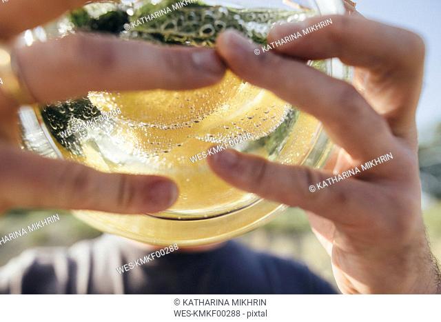 Detail of man drinking water infused with lemon and mint