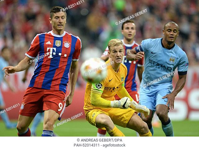 Bayern Munich's Robert Lewandowski (L) vies for the ball with Manchester's goalkeeper Joe Hart during the UEFA Champions League Group E soccer match between FC...
