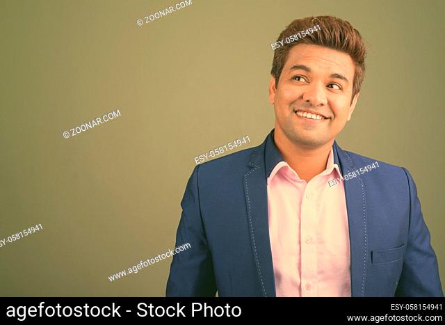 Studio shot of Indian businessman wearing suit against colored background