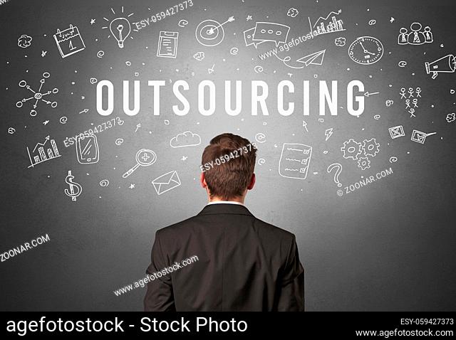 Rear view of a businessman with OUTSOURCING inscription, modern business concept