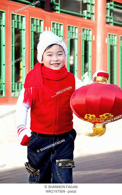 Boy holding red lantern in Courtyard